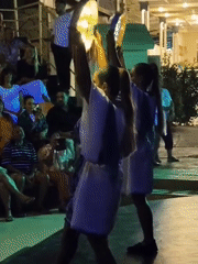 Traditional stage performance with flags and lit props in Kuşadası