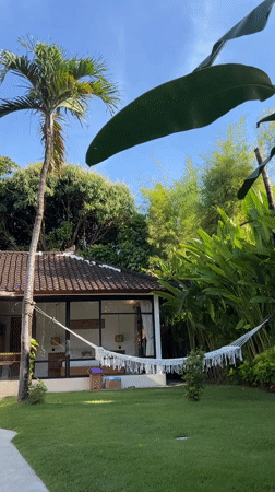 Person enjoys morning hammock time with iced tea in Kuta