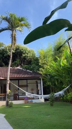 Person enjoys morning hammock time with iced tea in Kuta