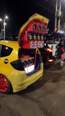 Young men gather around cars with speaker systems in Arica