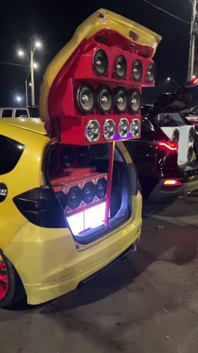 Young men gather around cars with speaker systems in Arica