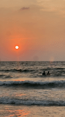 Two people enjoy ocean sunset at Choeng Thale beach