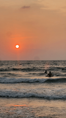 Two people enjoy ocean sunset at Choeng Thale beach