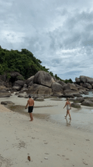 Overcast beach morning at Ko Samui with rocks, kayaks, and sand art