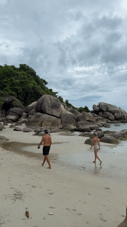 Overcast beach morning at Ko Samui with rocks, kayaks, and sand art