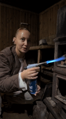 Woman lights old cast iron stove in rural Russia
