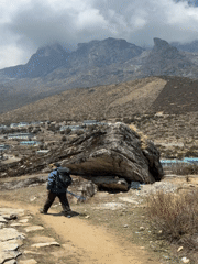 Trekker approaches Khumjung village in Nepal mountains