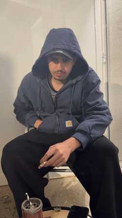 Young man smoking outdoors with food in Vila Real