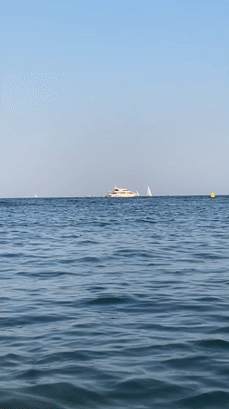Calm afternoon on the Costa Brava coast with boats and breakwater