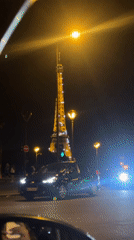 Evening scene captured at illuminated Eiffel Tower with pedestrian activity