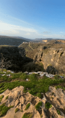 Person in red jacket views canyon from cliff in Bulgaria