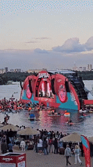 Waterfront festival stage lights up at dusk near Khimki