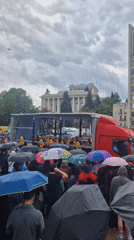 Crowd observes modified trailer with enclosed yellow-clad occupants