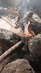 Indoor fire observed with rocks, wood, and tools