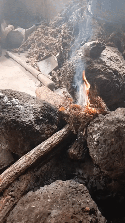 Indoor fire observed with rocks, wood, and tools