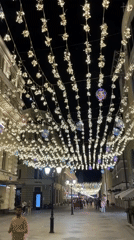 Nighttime pedestrian street lit with decorative overhead lights