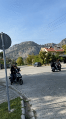 Children play, scooters navigate streets in sunny Fethiye afternoon
