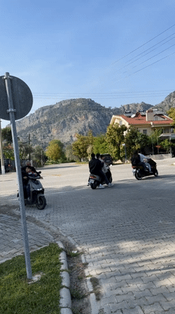 Children play, scooters navigate streets in sunny Fethiye afternoon