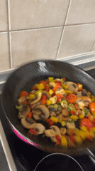Home cook prepares vegetable sauté with halloumi in Budapest
