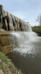 Concrete dam overflows creating waterfall in Kamennoye, Russia