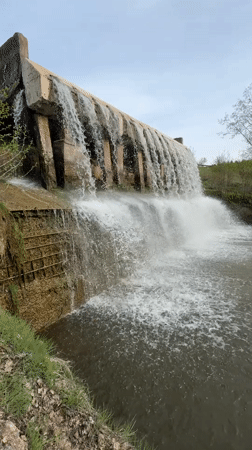 Concrete dam overflows creating waterfall in Kamennoye, Russia