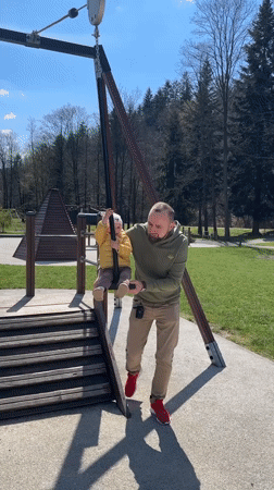 Adult helps child at playground in Wisła, Poland