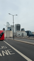 Pedestrians walk London street near Walkie Talkie building