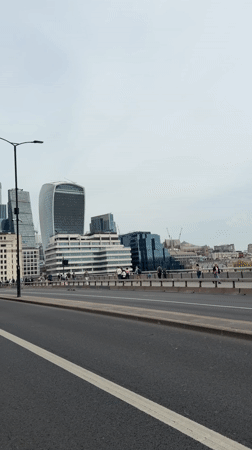 Pedestrians walk London street near Walkie Talkie building