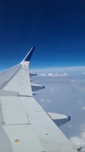 Passenger films airplane wing during morning flight over New Delhi