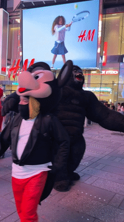 Late-night Times Square street performers and crowds, August 2026