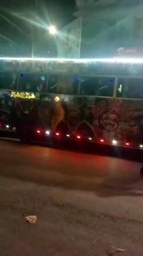 Pedestrian walks past decorated bus in Nairobi street