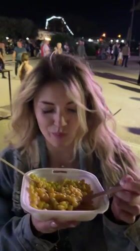 Woman eats pasta outdoors at night in Bar, Montenegro