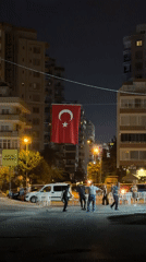 Turkish flag suspended over a lit Alanya street at night