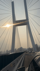 Morning traffic crosses sunlit Nanpu Bridge in Shanghai