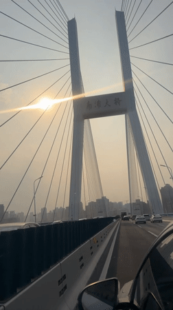 Morning traffic crosses sunlit Nanpu Bridge in Shanghai