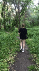 Red-haired person walks forest path near Kharkiv