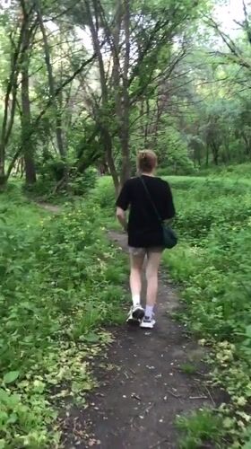 Red-haired person walks forest path near Kharkiv