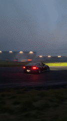 Multiple cars drifting at a track as dusk sets in
