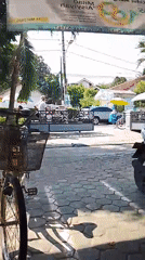 Bicycles and motorcycles parked on a Karanglewas cobblestone street