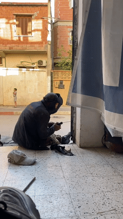 Welder repairs metal gate on street in Baraki, Algeria