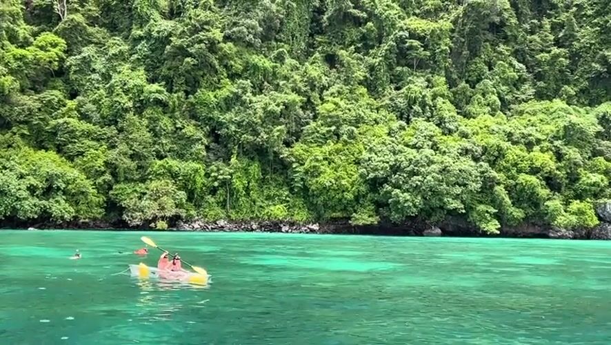 Boats and kayaks on the turquoise waters off Ao Nang