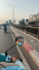 Helmeted rider crosses bridge on electric scooter in Vietnam