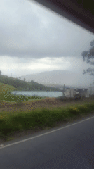 Highway scenery captured near Quito shows green hills, flowers