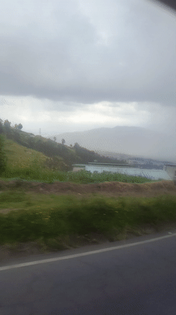 Highway scenery captured near Quito shows green hills, flowers