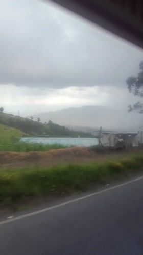 Highway scenery captured near Quito shows green hills, flowers