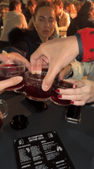 Friends toast with drinks at outdoor Biarritz restaurant