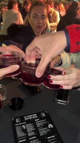 Friends toast with drinks at outdoor Biarritz restaurant