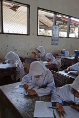 Students study in Indonesian classroom during early morning hours