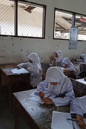 Students study in Indonesian classroom during early morning hours