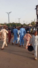 Traditional-dressed crowd walks through Arawa, Nigeria streets